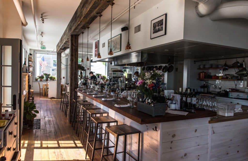 A restaurant with a long wooden bar and stools