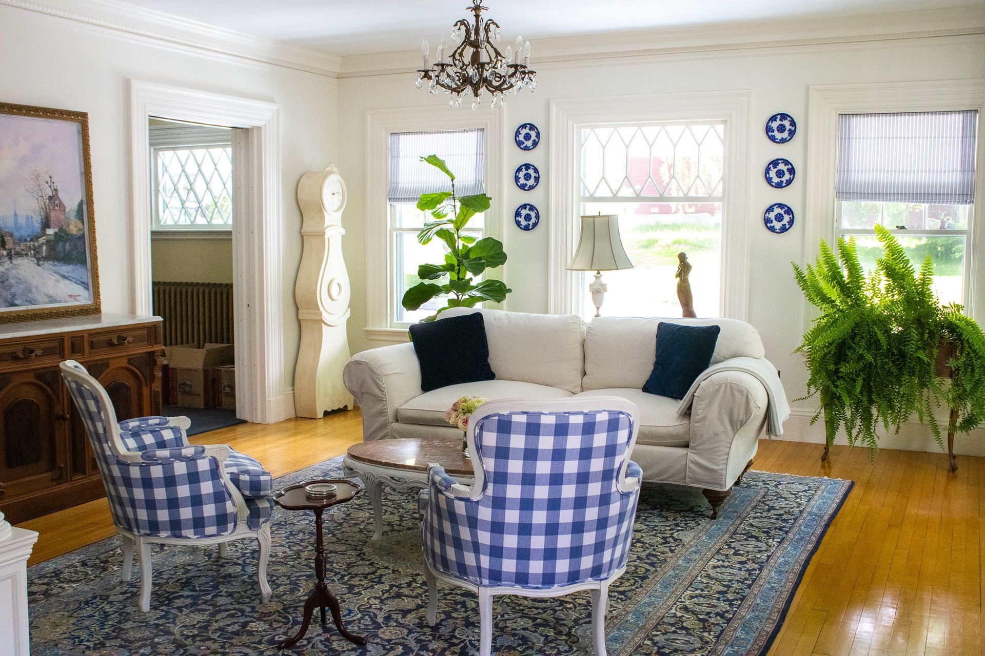 A living room with a white couch and blue chairs