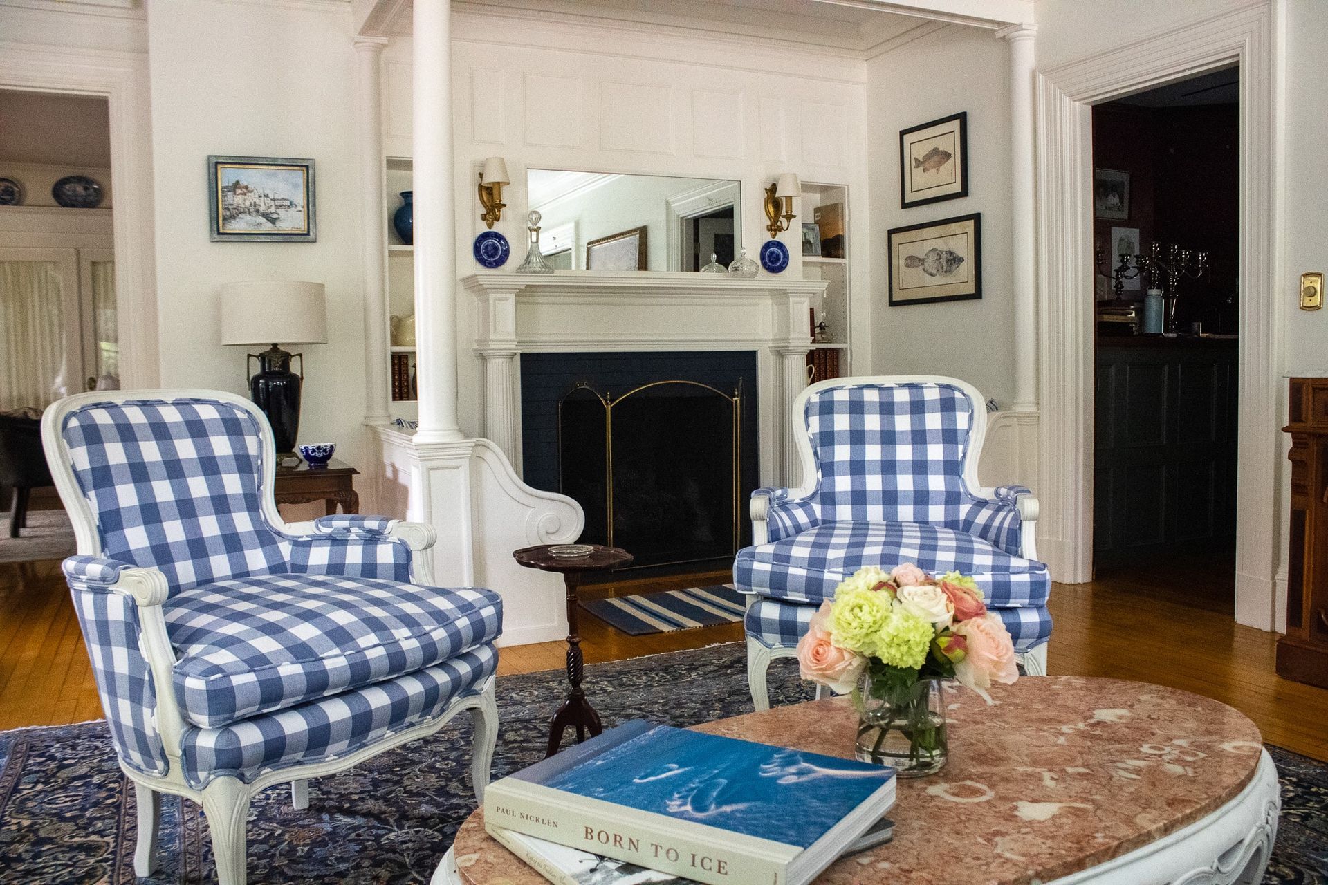 A living room with blue and white chairs and a fireplace.
