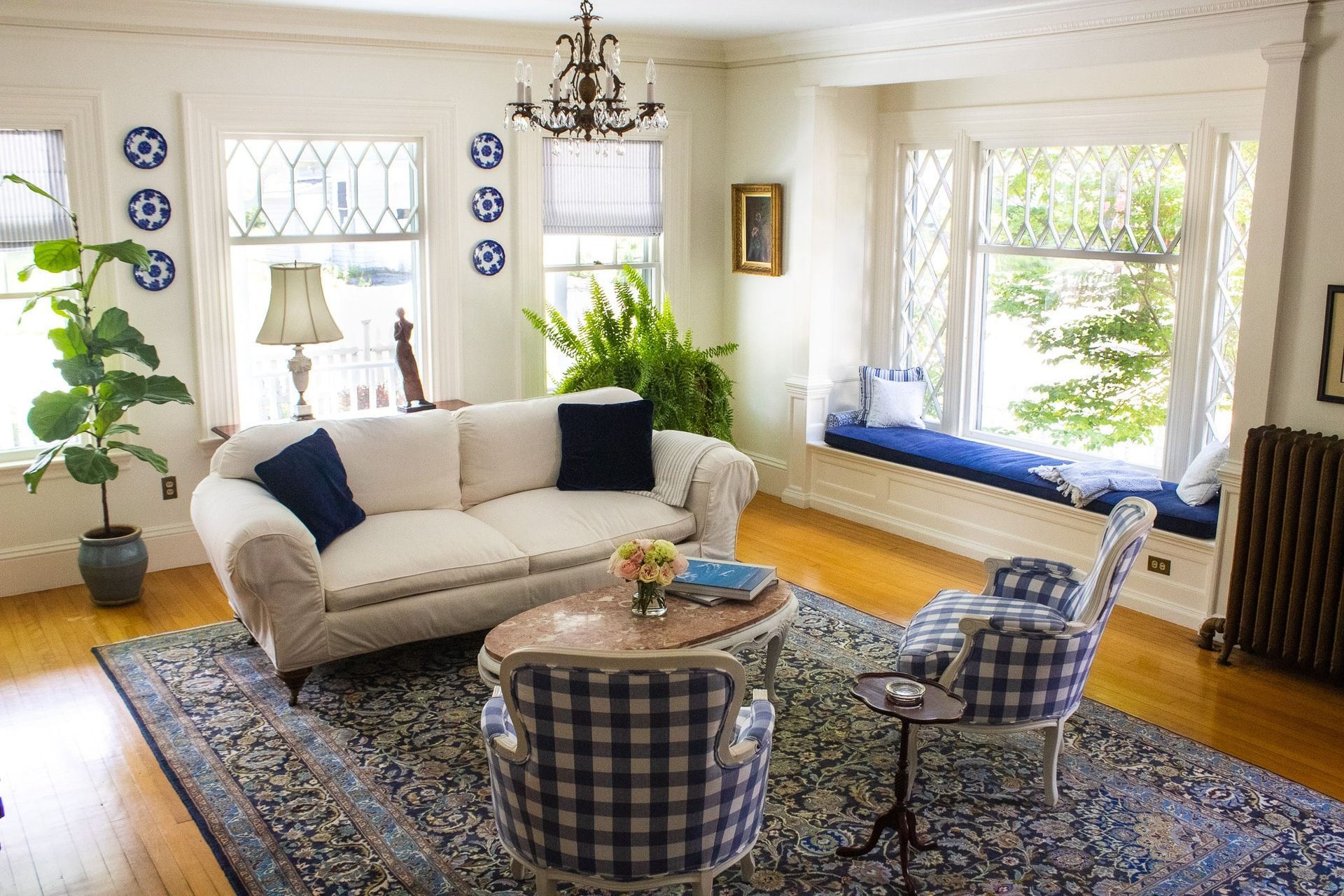 A living room with a couch , chairs , and a rug.