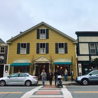 A yellow building with black shutters on the windows