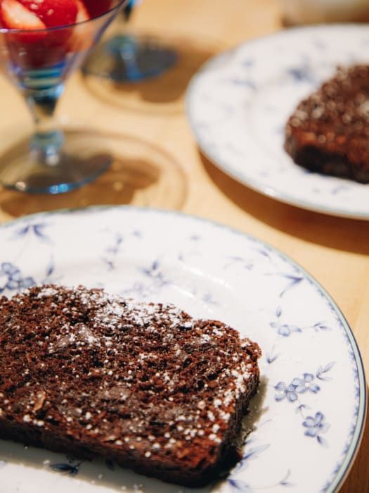 A white plate with a piece of chocolate cake on it