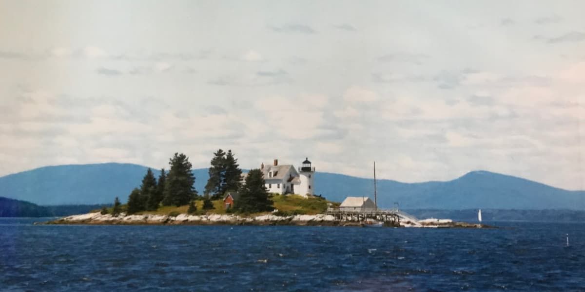 A small island with a lighthouse on top of it