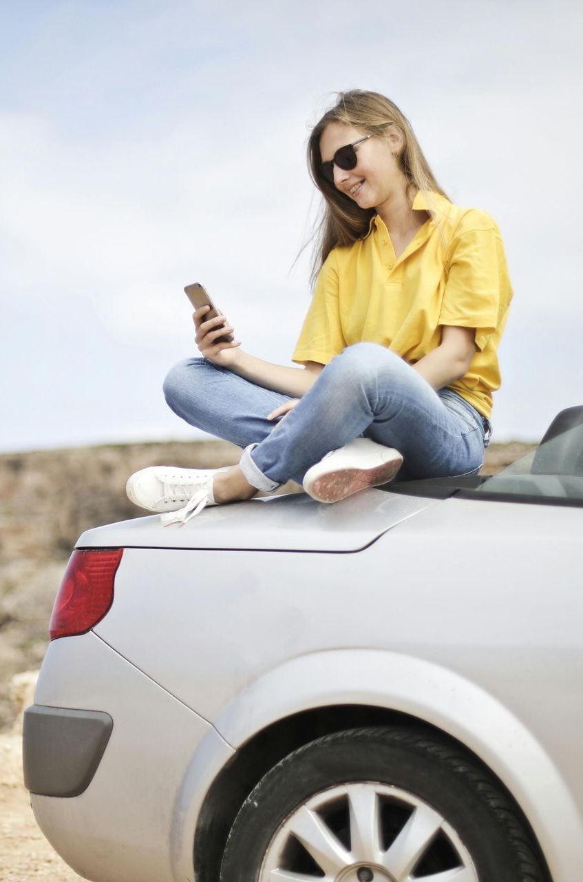 A woman is sitting in a chair looking out of a window.