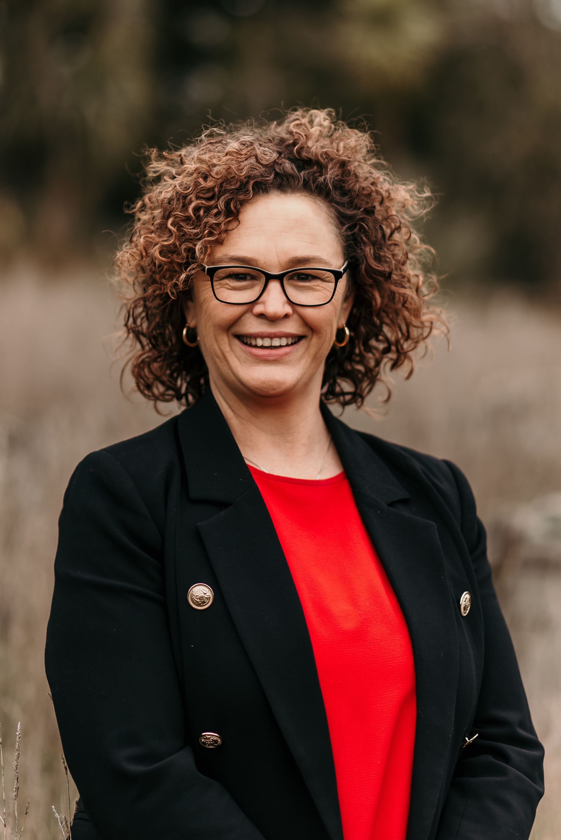 A woman with curly hair is smiling in a circle