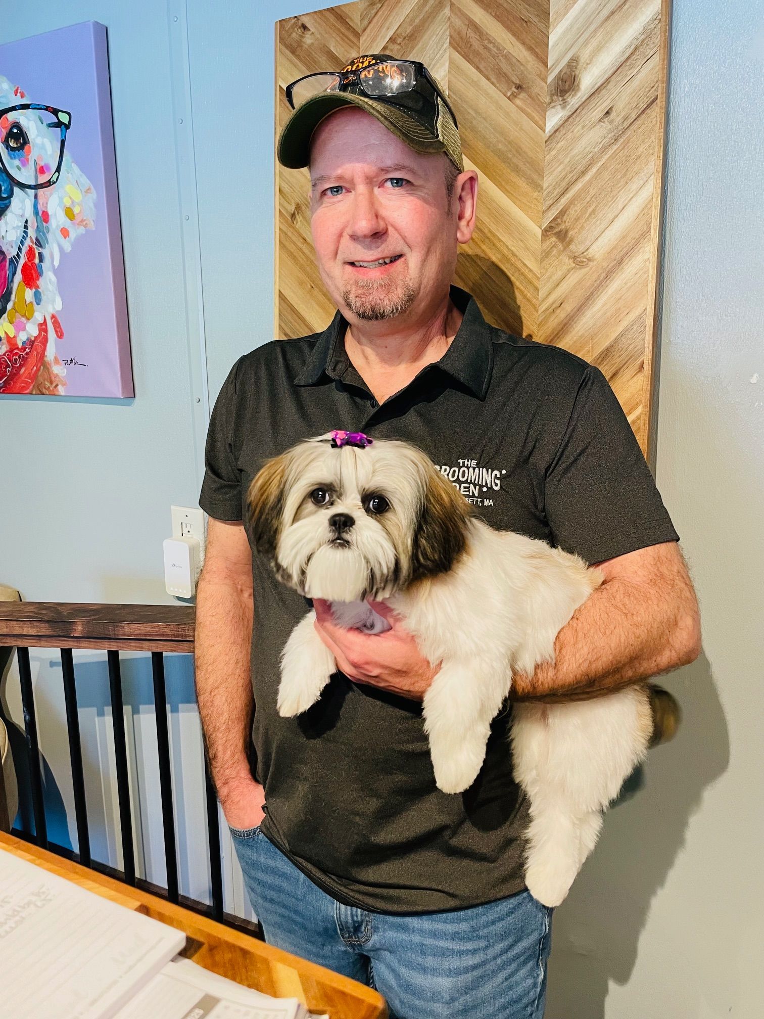 A man is holding a small dog in his arms.