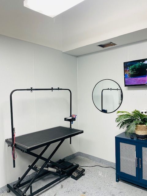 A room with a table and a tv on the wall