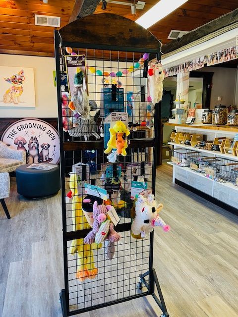 A bunch of stuffed animals are hanging on a rack in a store