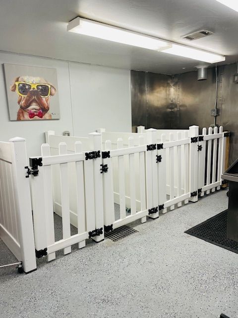 A room with a white fence and a picture of a dog on the wall.