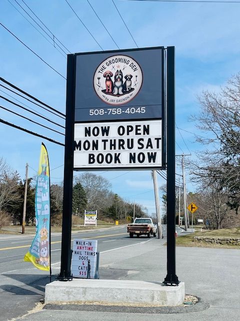 A sign on the side of a road that says now open month saturday book now