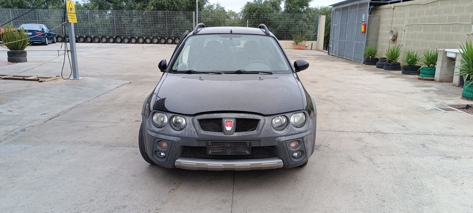 Una Rover Streetwise grigio scuro parcheggiata su un piazzale di cemento.