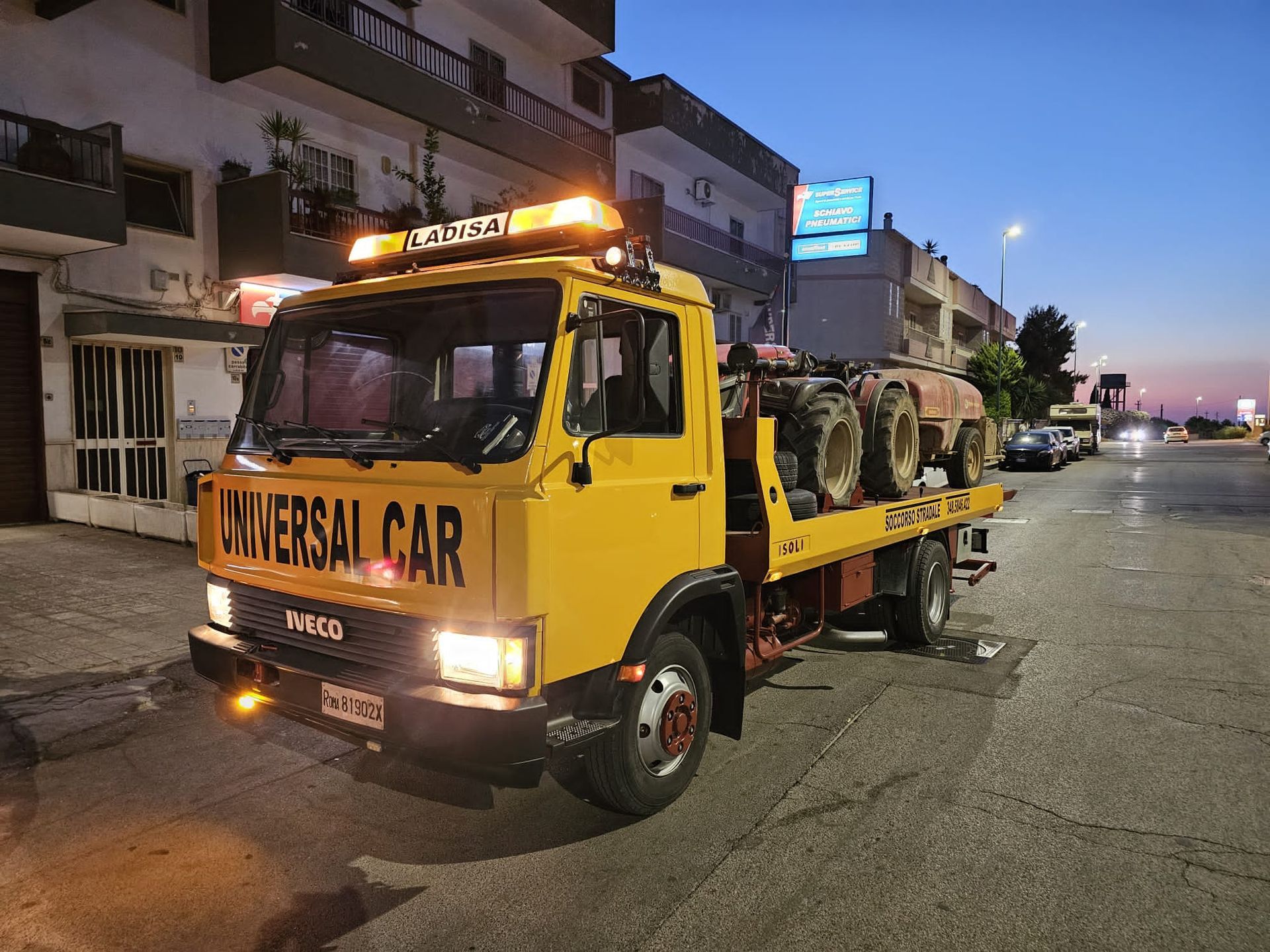 Un carro attrezzi Iveco giallo con la scritta