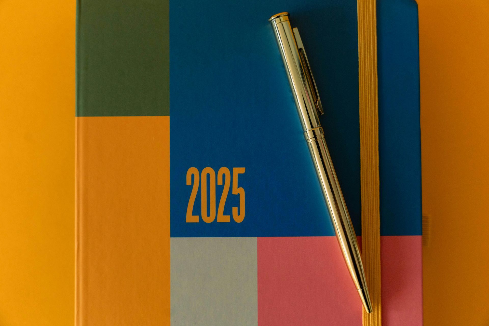 A pen is sitting on top of a colorful notebook.