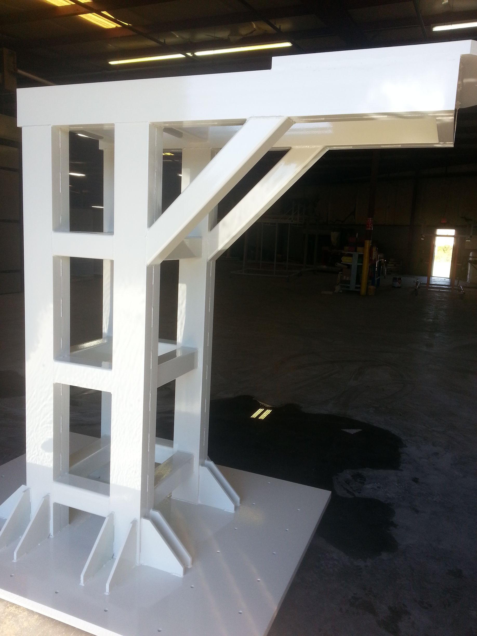 White industrial crane structure inside a warehouse.