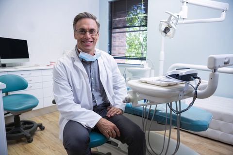 Financial Consultant — Smiling Doctor Sitting On Chair in Raleigh, NC