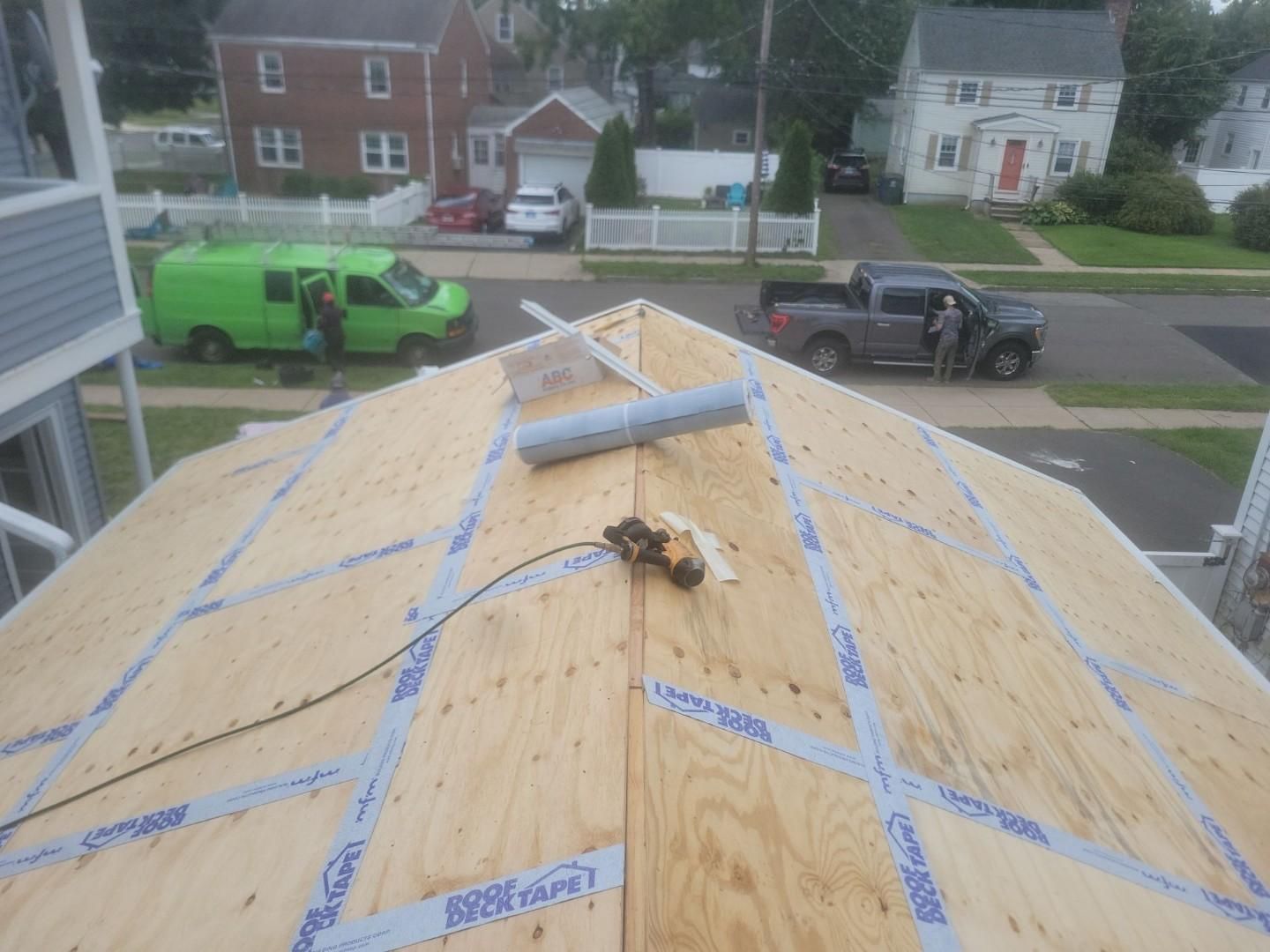 A green van is parked on the roof of a house.
