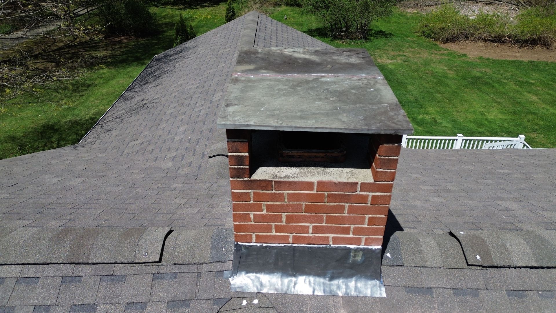 A brick chimney is sitting on top of a roof.