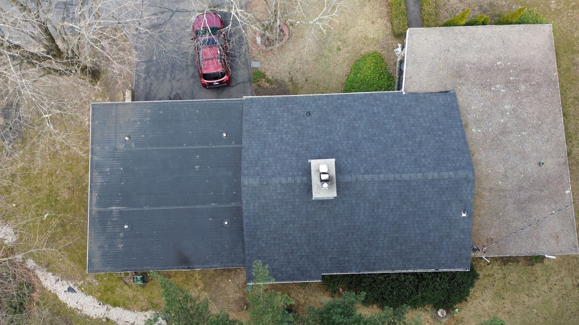 An aerial view of a house with a car parked in the driveway.