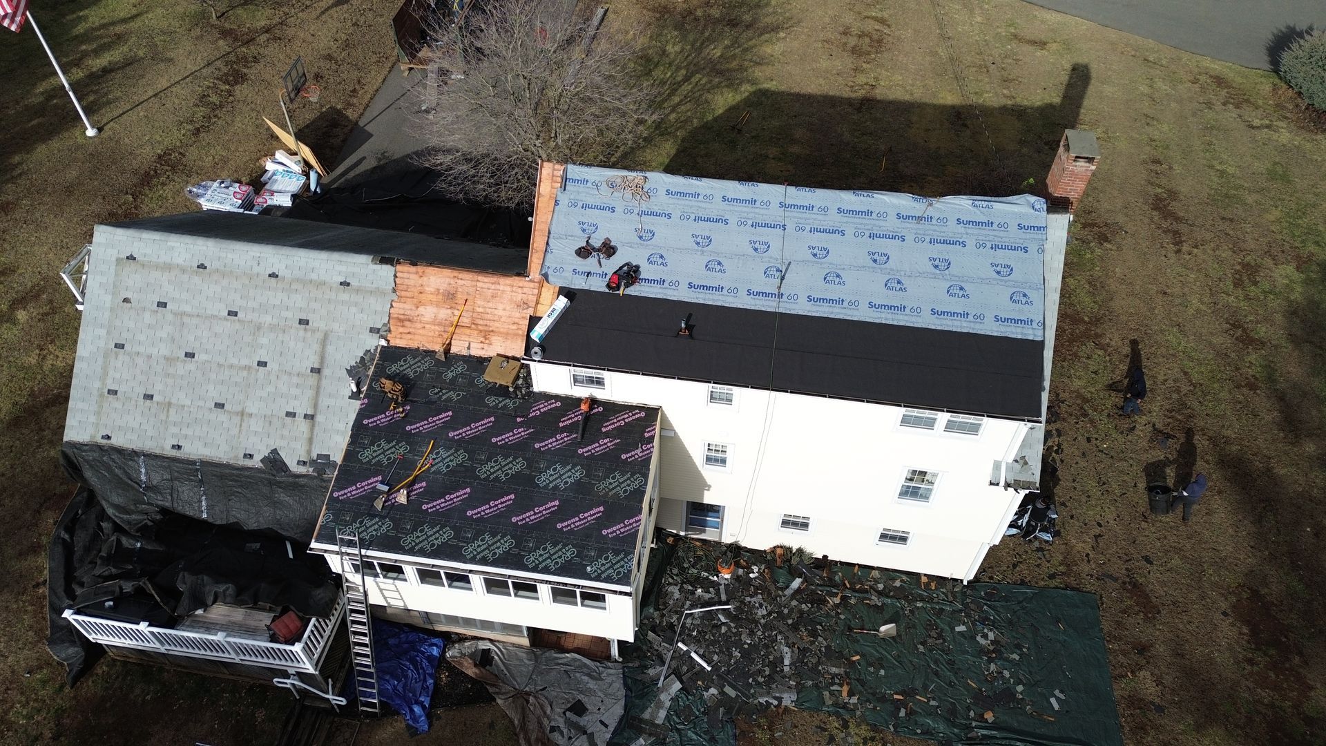 An aerial view of a house with a roof that is being repaired.