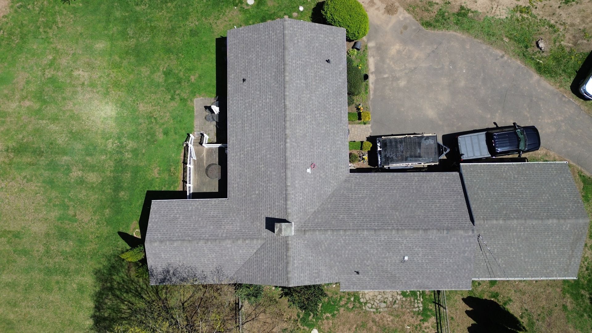 An aerial view of a house with two cars parked in front of it.