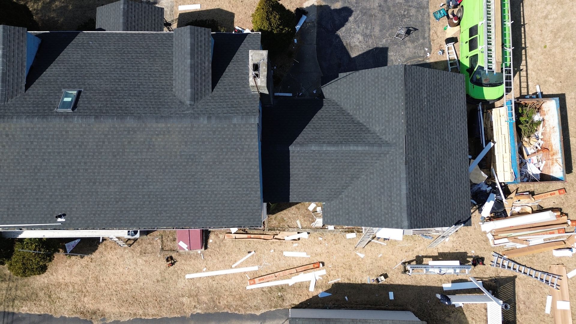 An aerial view of a house under construction with a green truck in the background.