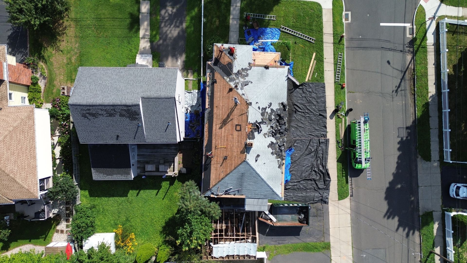 An aerial view of a house with a roof that is being repaired.