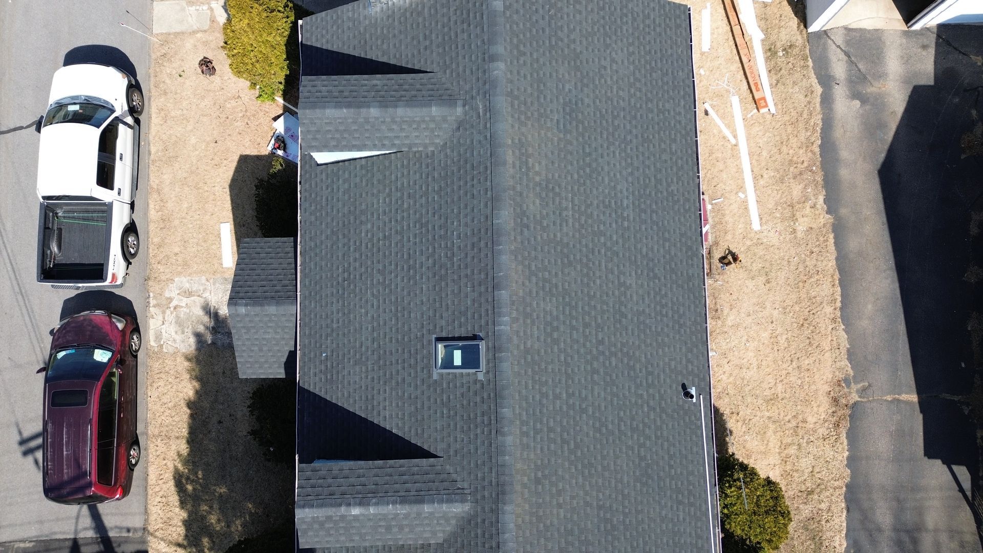 An aerial view of a house with cars parked in front of it.