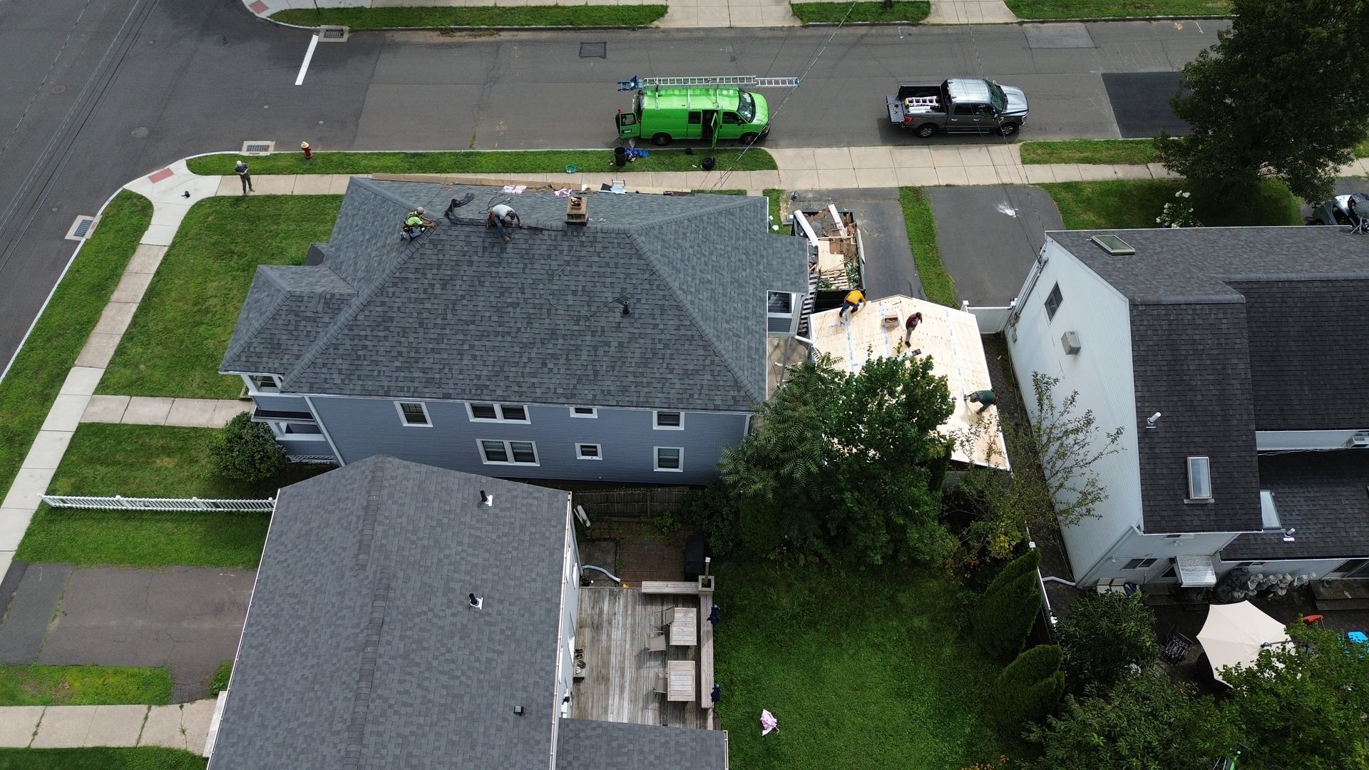 An aerial view of a house with a green van parked in front of it