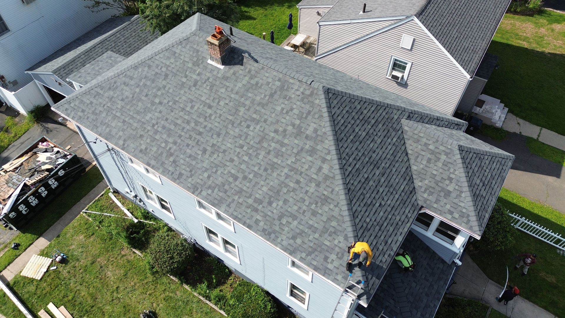 An aerial view of a house with a new roof being installed.