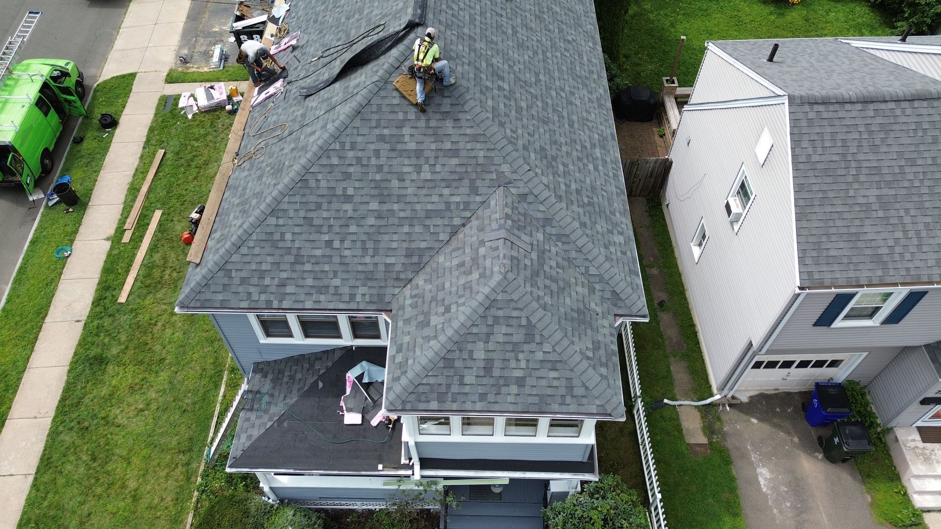 An aerial view of a house with a roof being repaired.