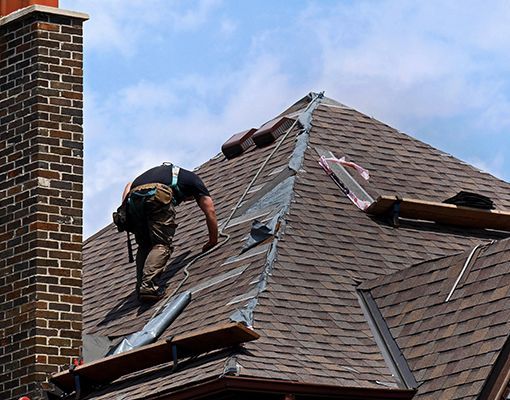 A man is working on the roof of a house.