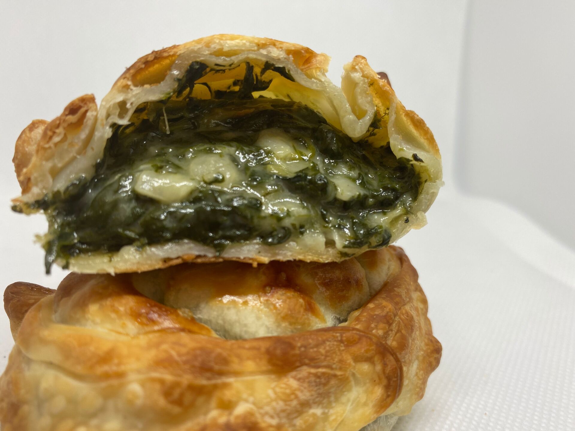 A baked spinach and cheese pastry, cut open to reveal the filling.