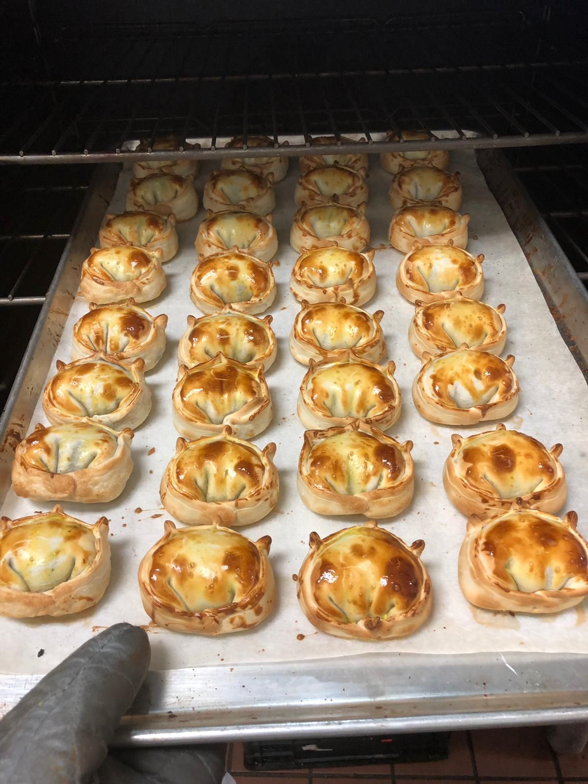 Tray of golden-brown baked pastries in an oven, ready to be served.