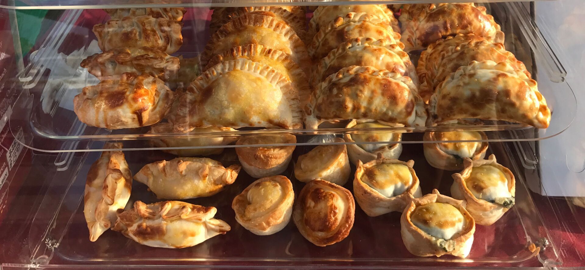 Pastries in a display case; a variety of shapes and sizes.
