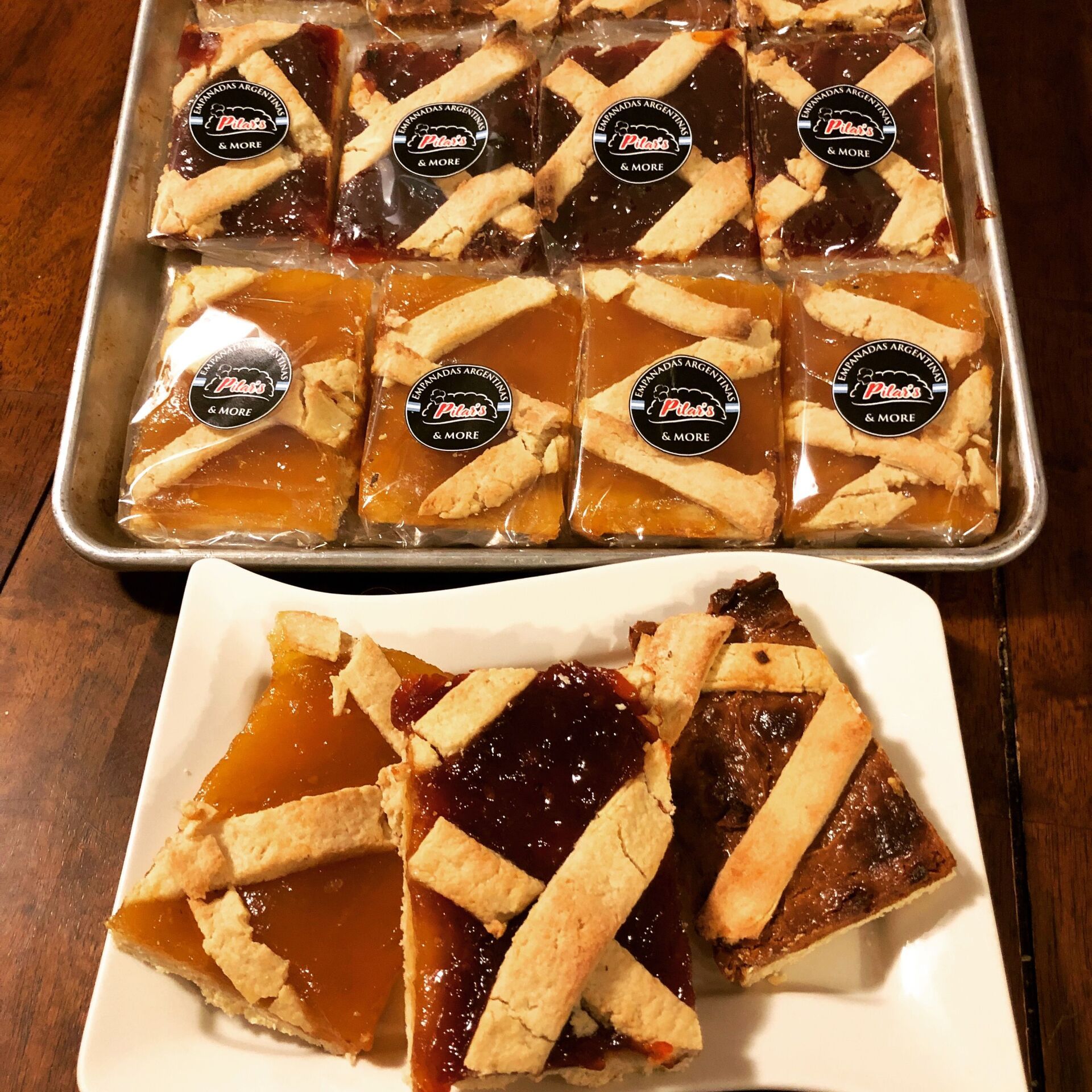 Tray of wrapped jam-filled tarts, some sliced on a plate.