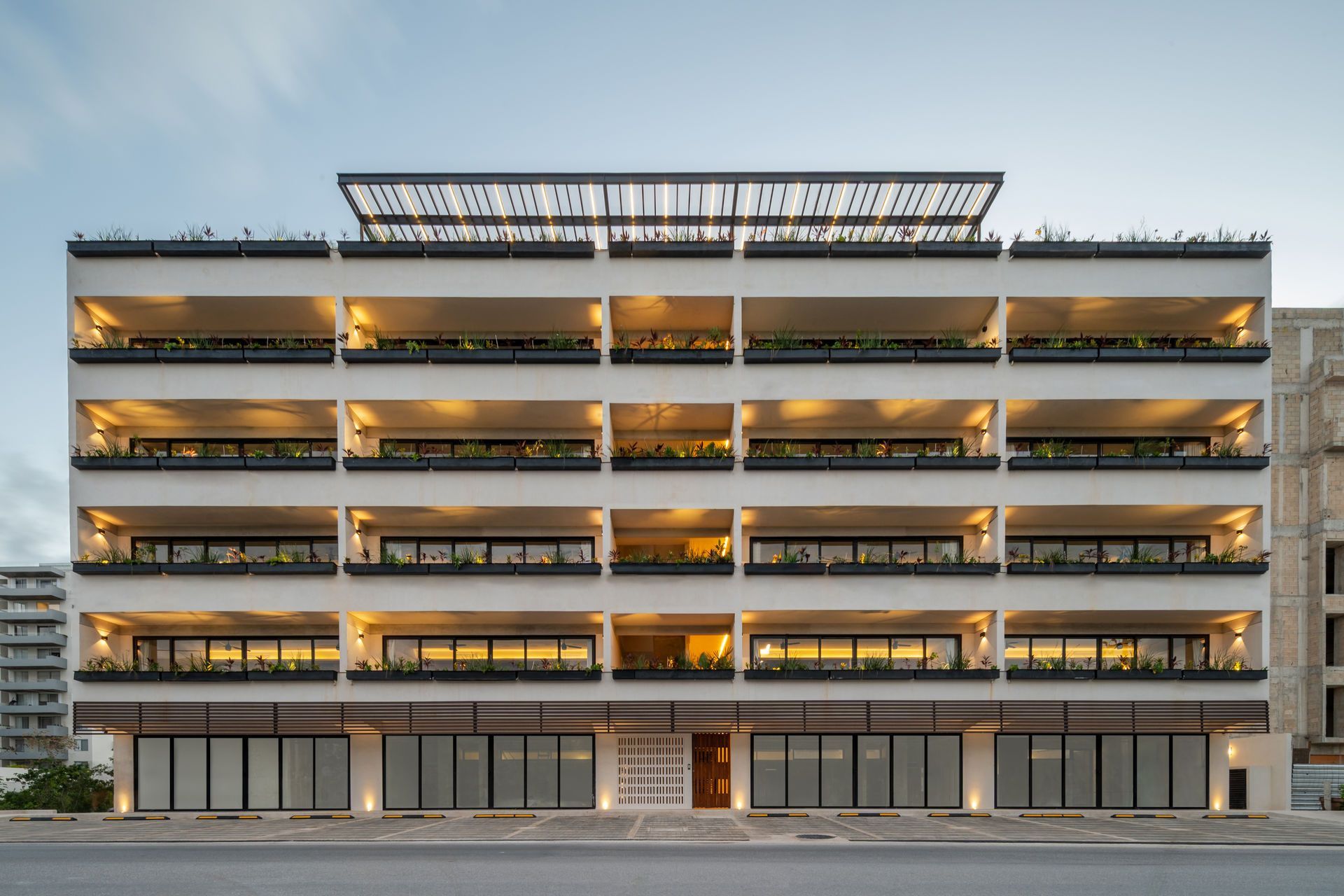 Un gran edificio con muchas ventanas y balcones está iluminado por la noche.