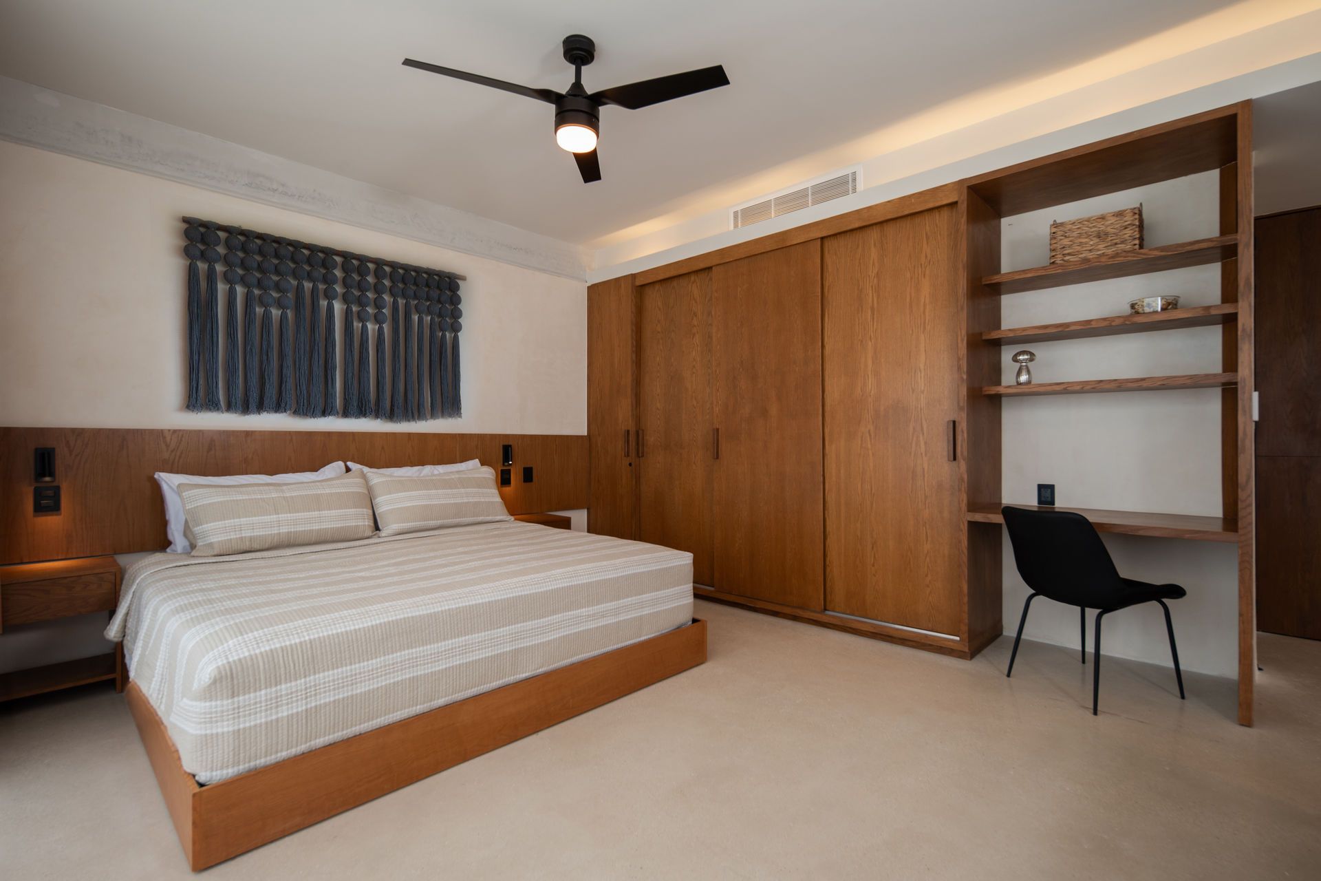 Hay un ventilador de techo en el dormitorio con una cama grande.