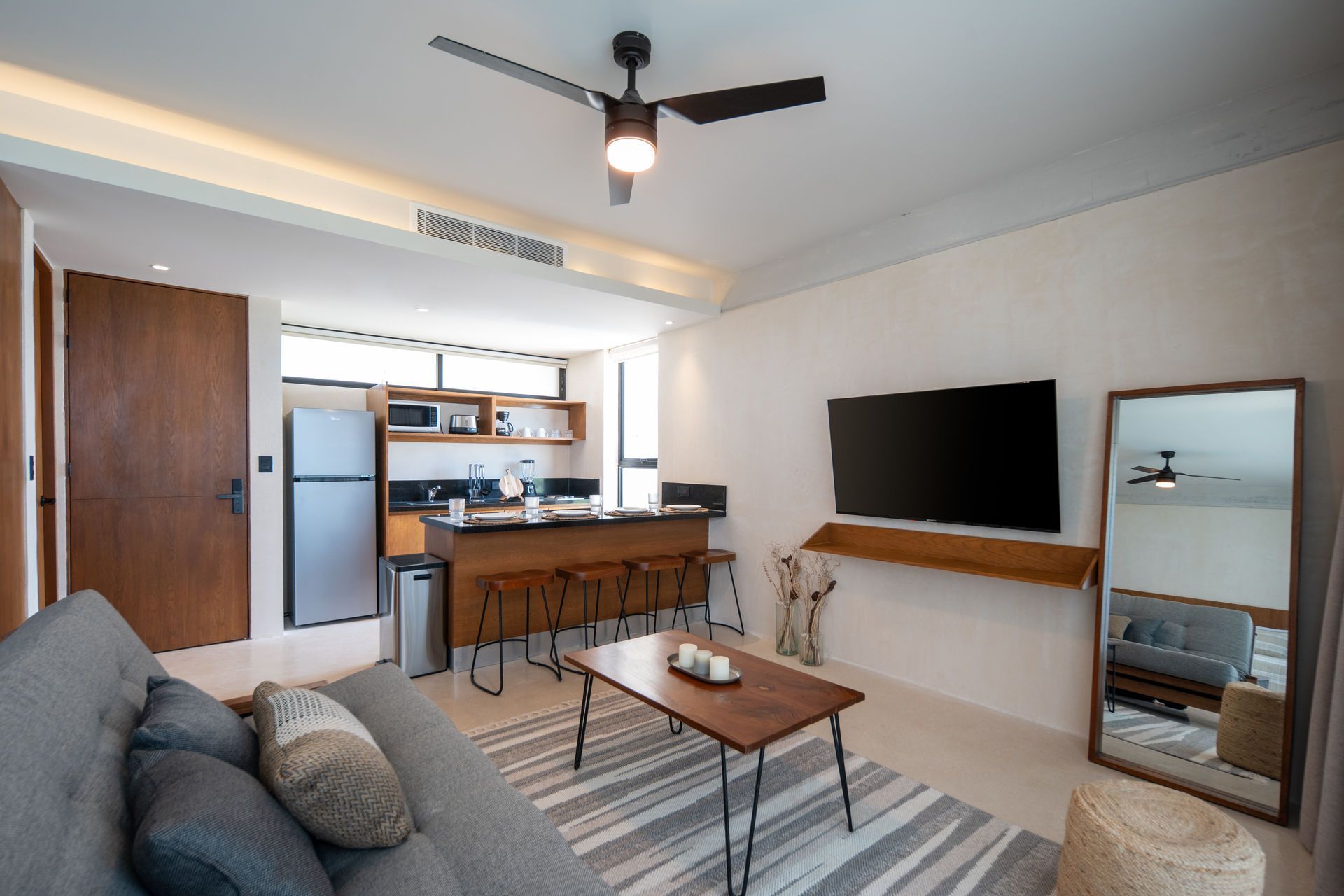 Una sala de estar con ventilador de techo y televisor de pantalla plana.