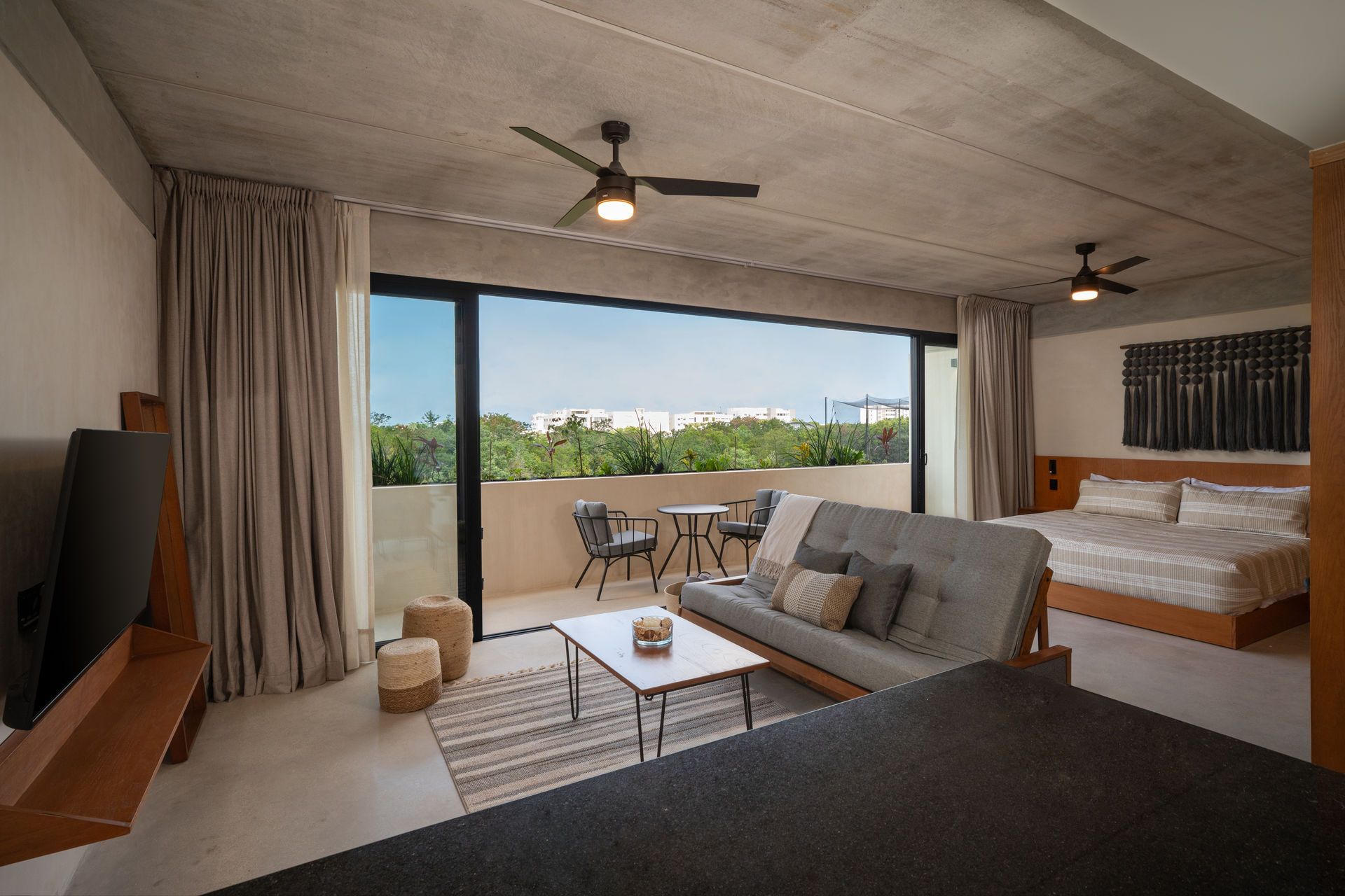 Una sala de estar con sofá, mesa y ventilador de techo.