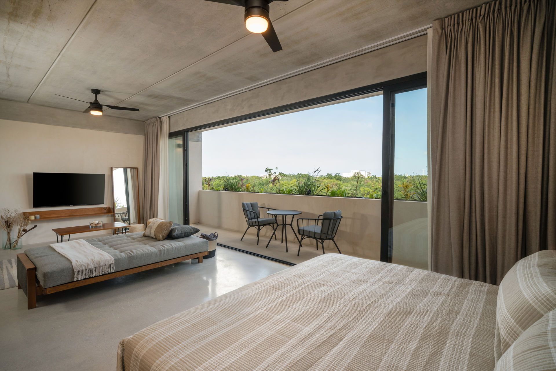 Un dormitorio con dos camas, televisión y balcón.