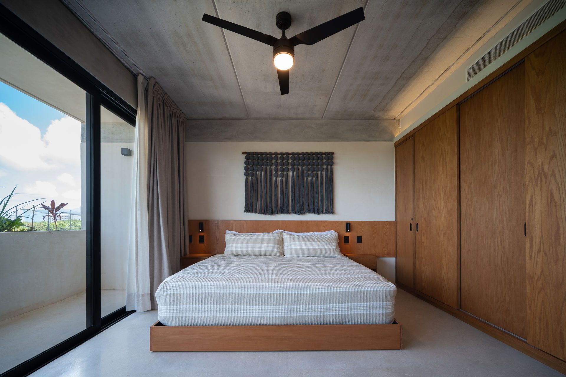 Un dormitorio con una cama grande y un ventilador de techo.