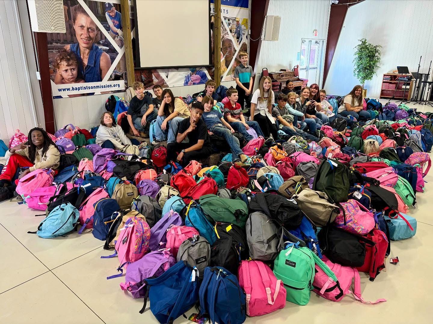 Classroom interior with tables, chairs, whiteboard, and learning materials.