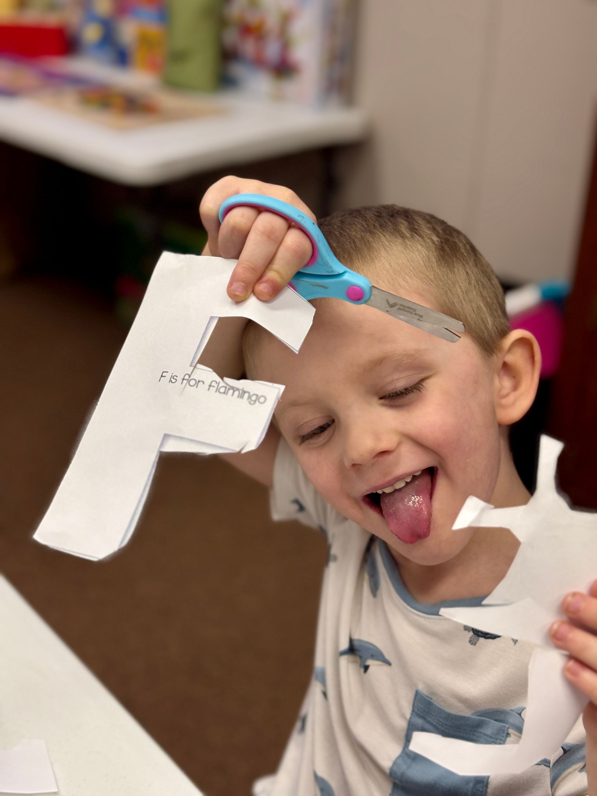 Boy with tongue out holding a paper
