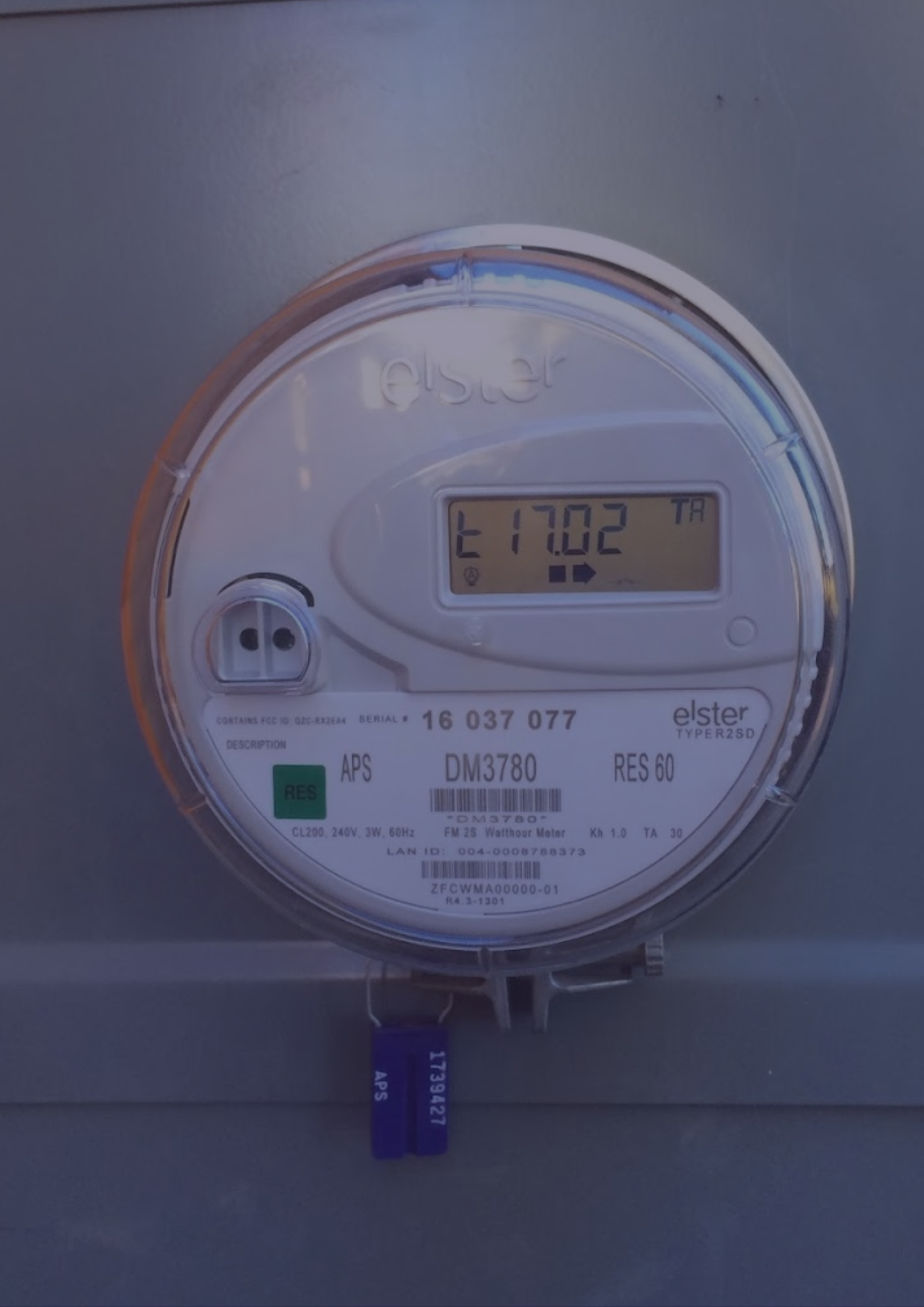 A close up of a digital electricity meter on a wall.