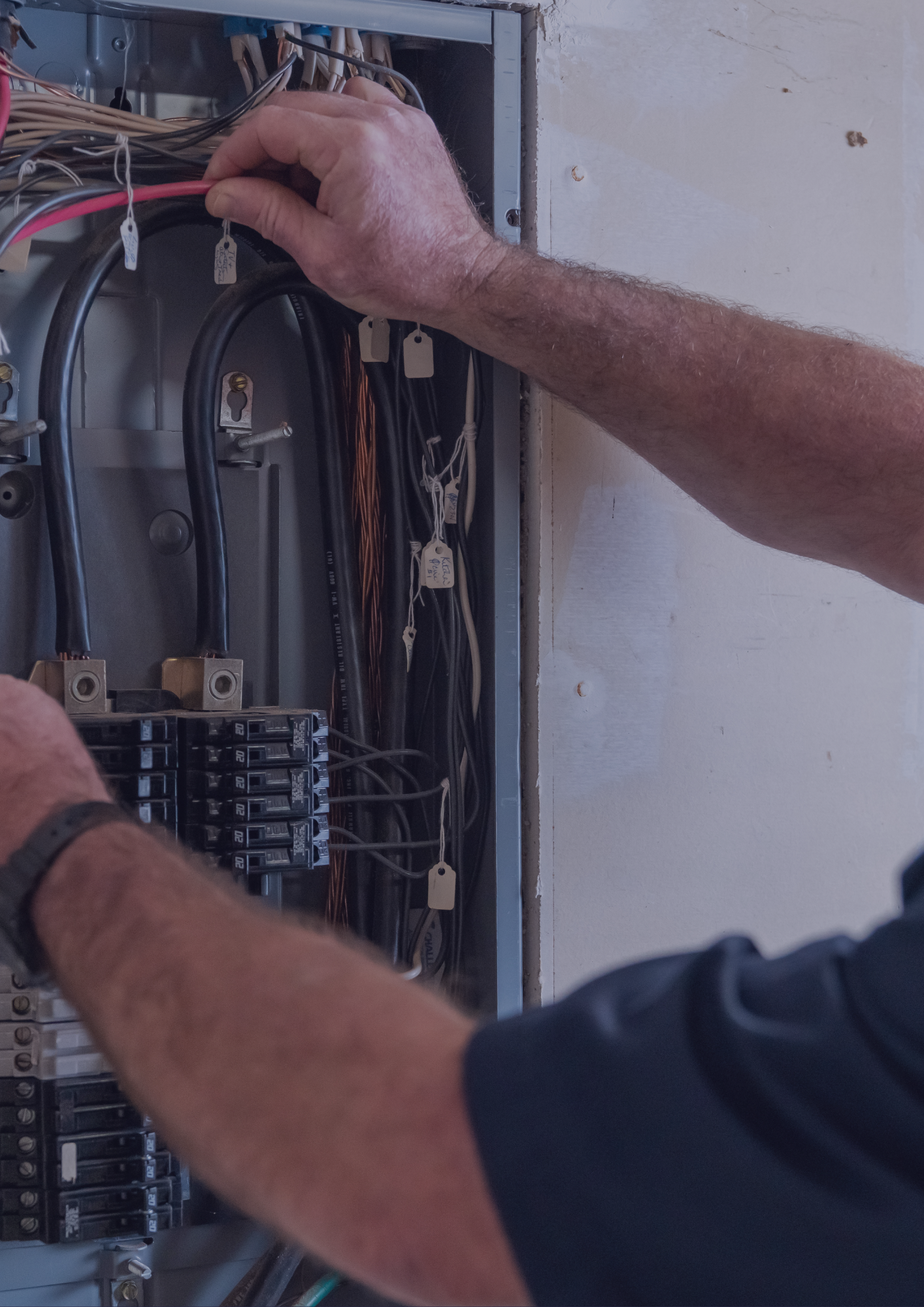A man is working on an electrical box.