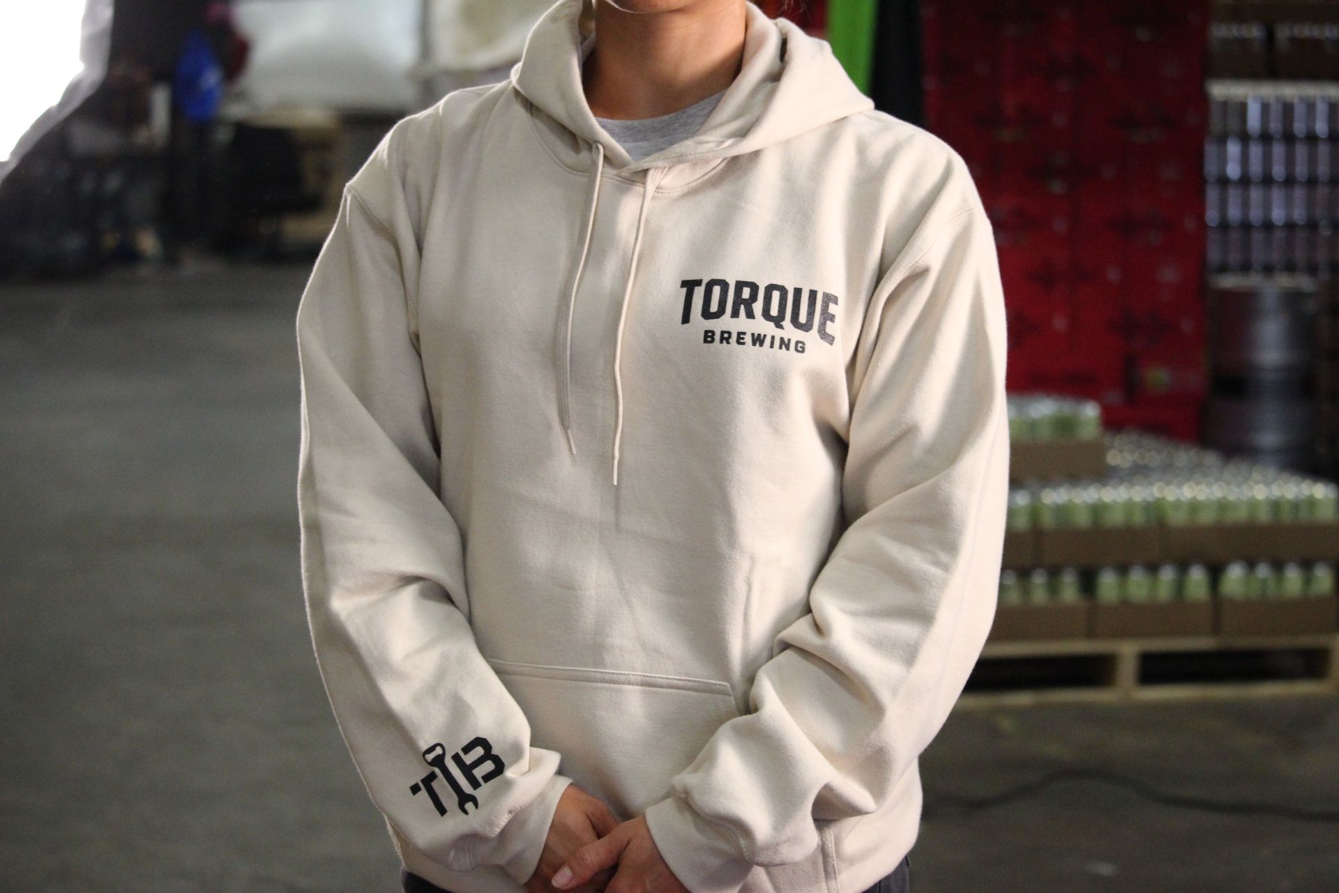 A person wearing a hoodie that says torque brewing