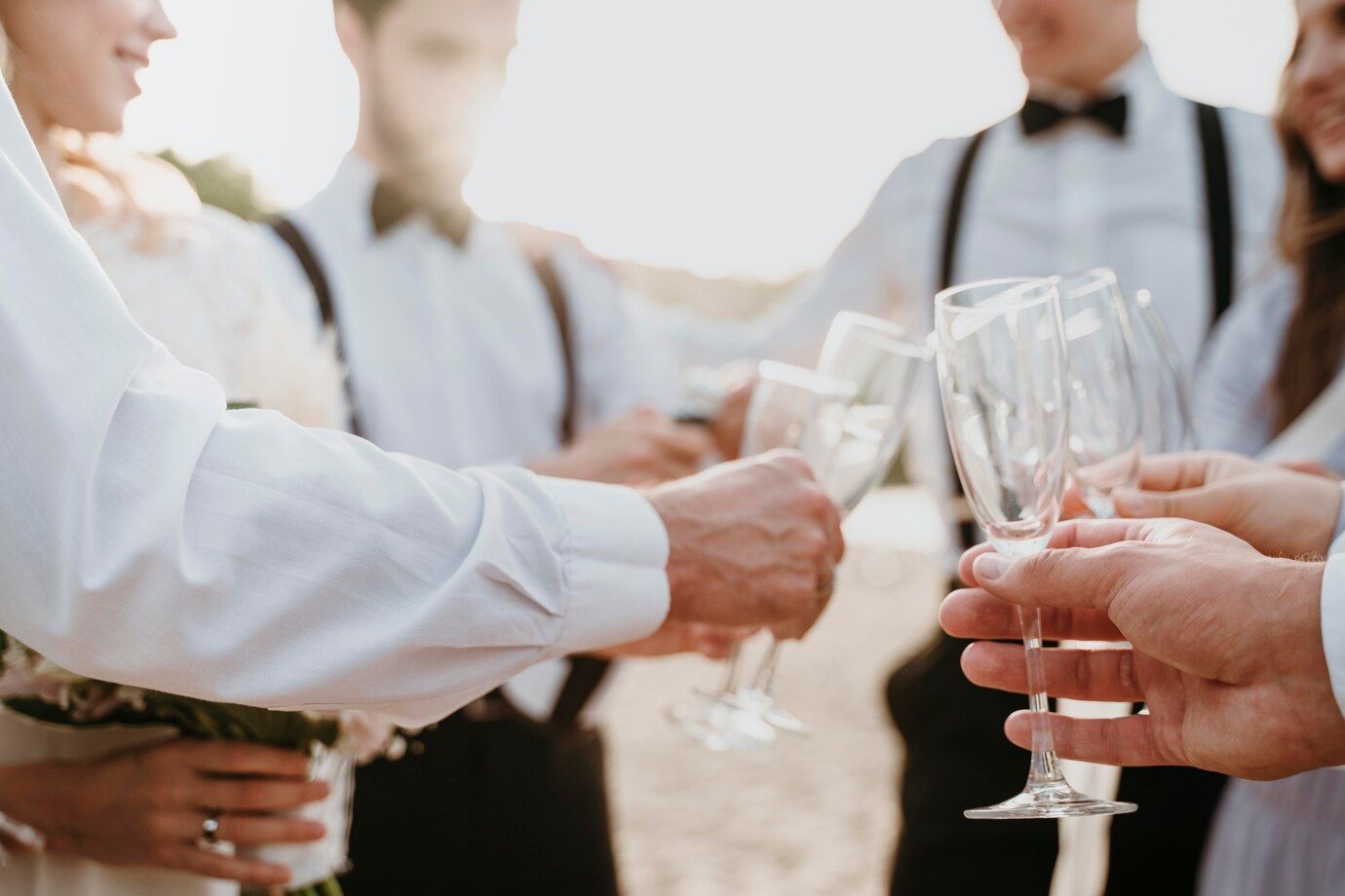 A group of people are holding champagne glasses in their hands.