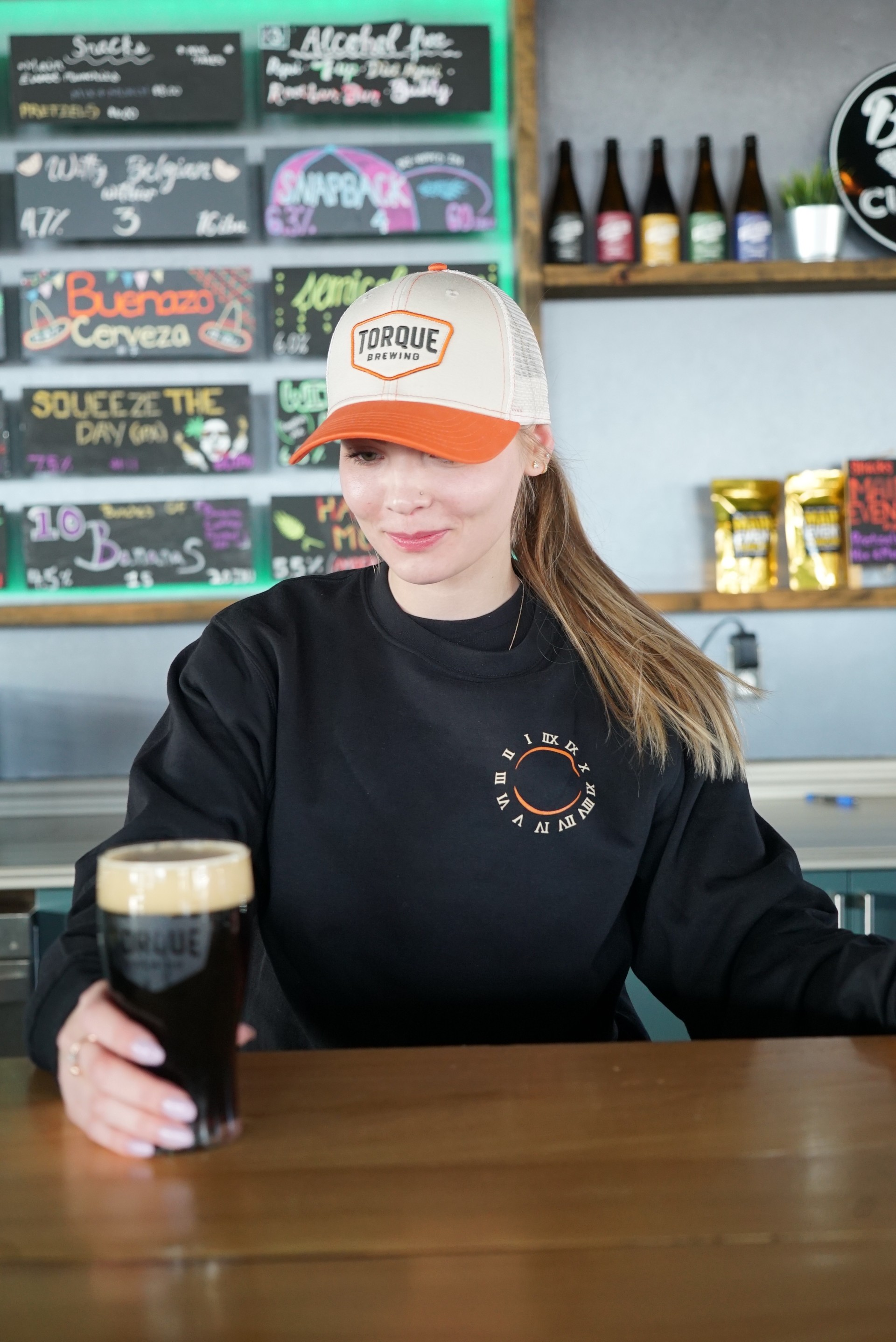 A person wearing a hoodie that says torque brewing