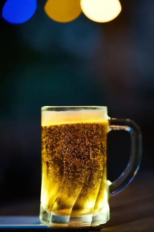 A glass of beer is sitting on a table.
