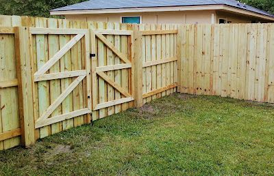 Wooden fence with gate in a backyard.
